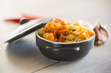 Et, kuru üzüm, sarımsak ve diğer malzemelerle ahşap bir masada pişirilmiş klasik pilav..