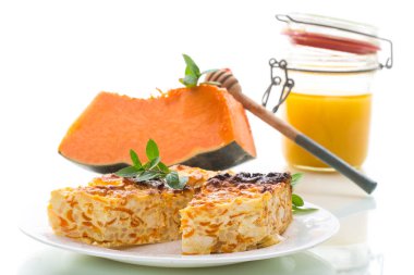 Beyaz arka planda izole edilmiş, içinde balkabağı parçaları olan süzme peynir güveci..