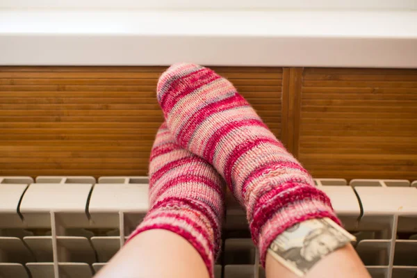 寒い冬の日にラジエーターで暖まる暖かい冬の靴下のフィート ロイヤリティフリーのストック写真