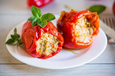 Doldurulmuş biberler içinde ahşap bir masada, bir tabakta.