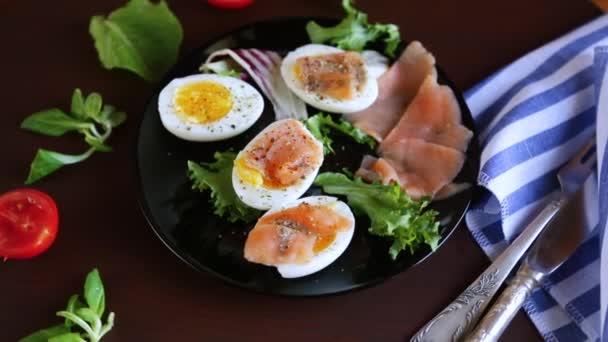 木製のテーブルの上の皿に塩漬けの赤魚 ハーブ 調味料で卵を煮ました 高品質のフルHd映像 — ストック動画