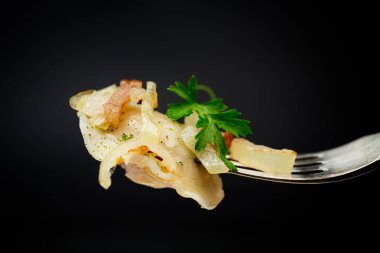 Patates ve mantarla doldurulmuş Ukrayna hamur tatlısı, kızarmış soğanla servis ediliyor. Siyah bir arka planda izole edilmiş. Yüksek kalite fotoğraf