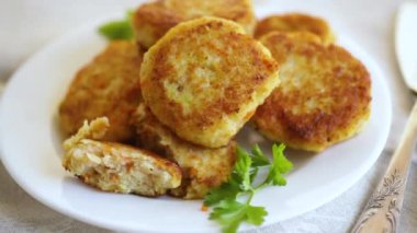 Hafif ahşap bir masada, otlarla dolu bir tabakta kızartılmış balık pirzolası. Yüksek kaliteli FullHD görüntüler