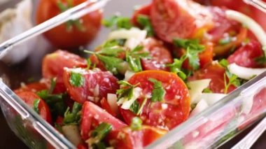 Baharatlı domatesler, sarımsak, ot, baharat ve cam kasede soğan. Yüksek kaliteli FullHD görüntüler