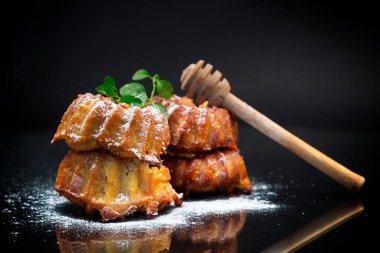 Siyah arka planda izole edilmiş pudra şekerli tatlı çörekler.