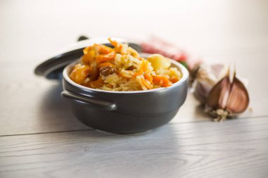 Et, kuru üzüm, sarımsak ve diğer malzemelerle ahşap bir masada pişirilmiş klasik pilav..