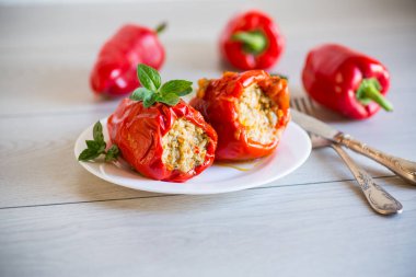 Doldurulmuş biberler içinde ahşap bir masada, bir tabakta.