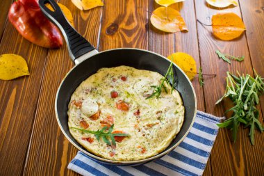 Ahşap bir masada kızartma tavasında çeşitli sonbahar sebzeleriyle kızarmış omlet. Sonbahar tarifleri.