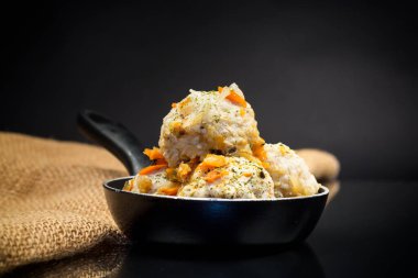 Kızartma tavasında pişmiş tavuk eti köftesi, siyah arka planda izole edilmiş.