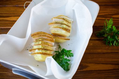 Domuz yağı ve baharatla doldurulmuş çiğ patates, fırın kağıdında pişirmeye hazır..