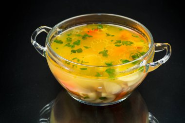 Sebzeli vejetaryen mantar çorbası ve siyah arka planda izole edilmiş makarna.