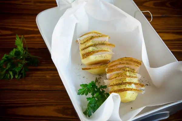 用猪油和香料填充的生土豆 准备在烤纸上烘烤 免版税图库照片