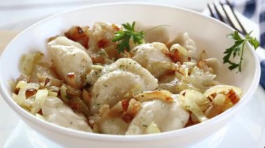 Patates ve mantarla doldurulmuş Ukrayna Vareniky veya Pierogi, kızarmış soğanla servis edilir. Ahşap masa arkaplanı.