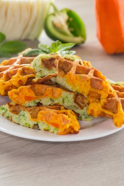 Tahta bir masada, lahana ve havuçtan yapılmış iki renkli sebze waffle 'ı..