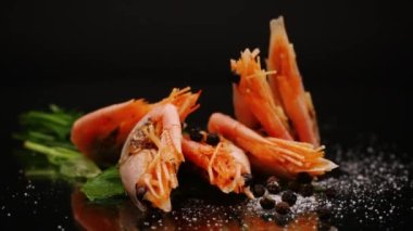 Siyah zemin üzerinde baharatlı haşlanmış karides.