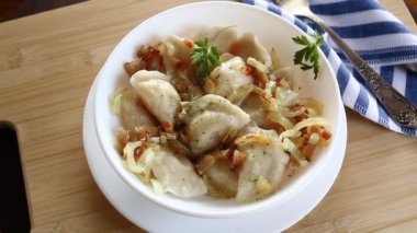 Patates ve mantarla doldurulmuş Ukrayna Vareniky veya Pierogi, kızarmış soğanla servis edilir. Ahşap masa arkaplanı.