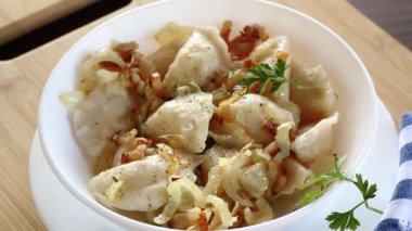Patates ve mantarla doldurulmuş Ukrayna Vareniky veya Pierogi, kızarmış soğanla servis edilir. Ahşap masa arkaplanı.