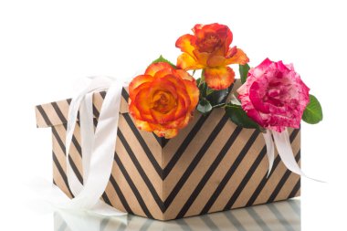 İçinde güzel güller ve kurdeleler olan hediye kutusu, beyaz arka planda izole edilmiş..