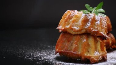 Siyah arka planda izole edilmiş pudra şekerli tatlı çörekler.