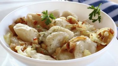 Patates ve mantarla doldurulmuş Ukrayna hamur tatlısı, kızarmış soğanla servis ediliyor. Ahşap masa arka planı. Yüksek kalite fotoğraf