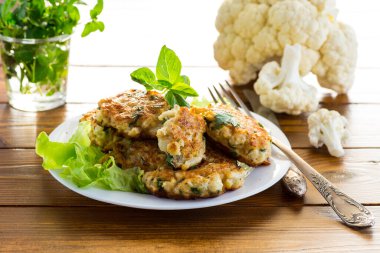 Pişmiş vejetaryen kızarmış karnabahar pirzolası, ahşap bir masada bir tabakta..