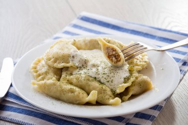 Et, baharat ve ekşi kremayla pişirilmiş hamur köfteleri, açık ahşap bir masada. Ukrayna yemekleri.