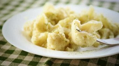 Pişmiş karnabahar, buğulanmış, ahşap bir masada baharatlı bir tabakta..