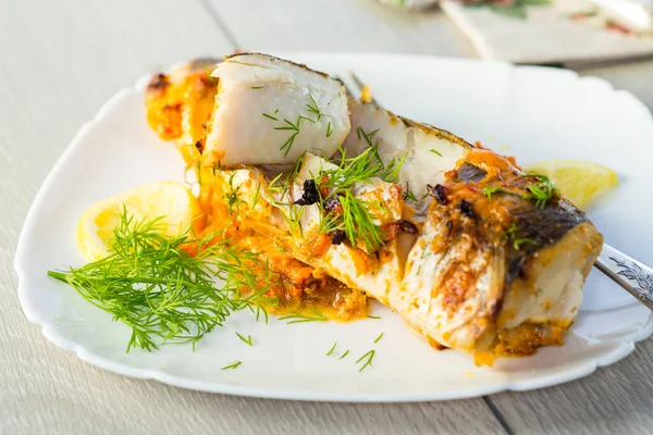 테이블에 접시에 오븐에 향신료와 야채로 물고기 스톡 사진