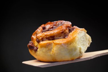 Pişmiş tatlı çörek ve çikolata dolgulu, siyah arka planda izole edilmiş.