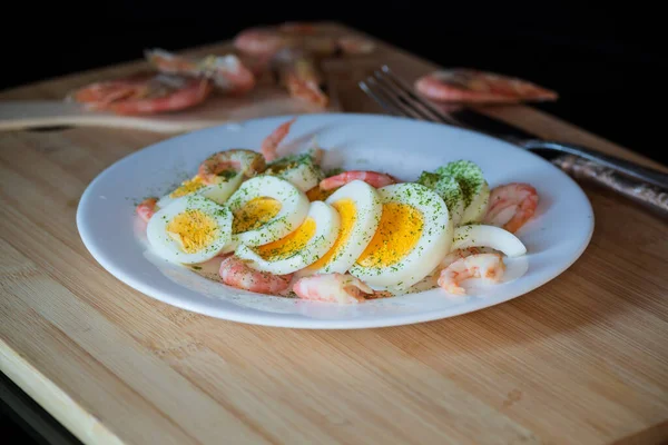 煮熟的鸡蛋 虾仁放在盘子里当早餐 放在木板上 — 图库照片