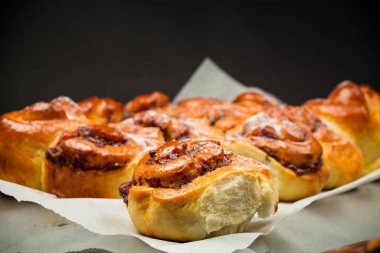 Pişmiş tatlı çörek ve çikolata dolgulu, siyah arka planda izole edilmiş.