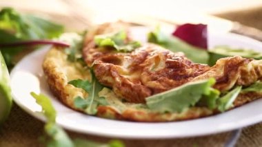 Kızarmış omlet, kabak ve ahşap bir masada otlar..