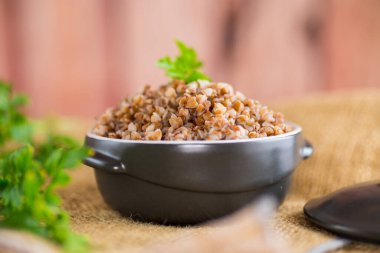 ahşap bir masa üzerinde bir seramik kase haşlanmış buğday.