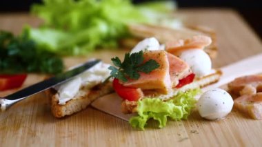 Kızarmış ekmek, somon, krem peynir, salata, ahşap bir masada. .