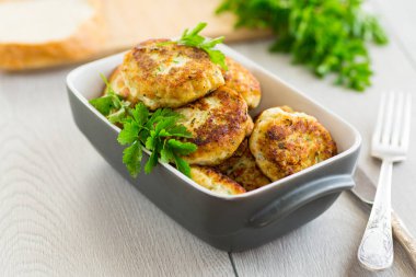 Ahşap bir masada seramik bir formda kızarmış et pirzolası. .