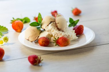 Çilekli taze organik süzme peynir ve ahşap bir masada duran dondurma. .