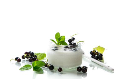 Beyaz arka planda izole edilmiş, siyah üzümlü kavanozda ev yapımı tatlı yoğurt. .