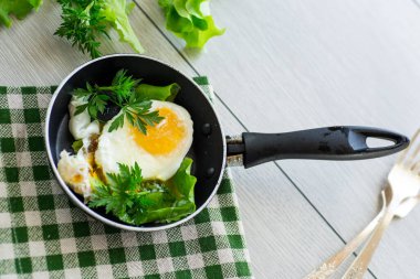 Kızartma tavasında yumurta ve şifalı otlar. .