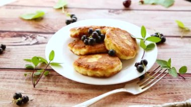 Kızarmış peynirli krep, siyah üzümlü, ahşap bir masada. .