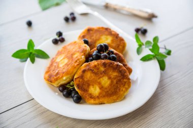 Kızarmış peynirli krep, siyah üzümlü, ahşap bir masada. .