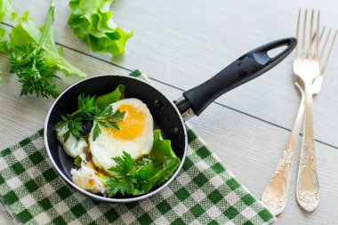 Kızartma tavasında yumurta ve şifalı otlar. .