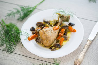 Mantarlı kızarmış tavuk ve ahşap bir masada bir tabakta sebze. .