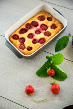 Çilek dolgulu, ahşap bir masada, süzme peynir güveci.