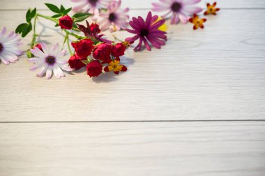 Hafif ahşap arka plan ve küçük yaz çiçekleri .