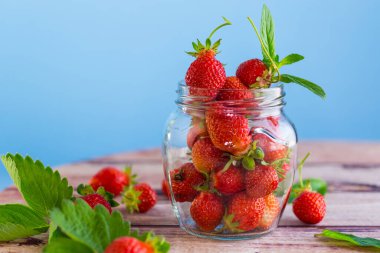 Cam kavanozda taze kırmızı çilekler. .