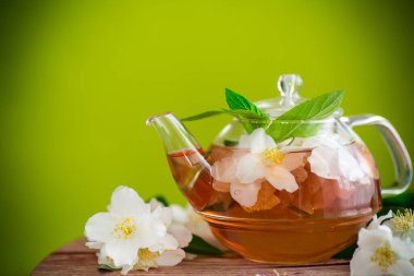 jasmine flower tea in a glass teapot . clipart