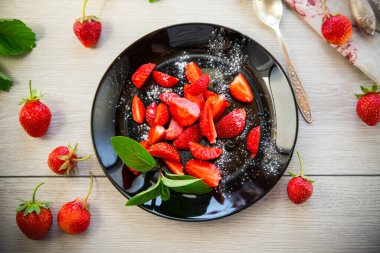 Hafif ahşap bir masada olgun çilek salatası. .