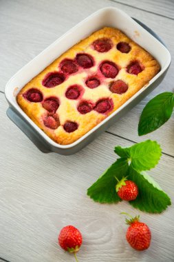 Çilek dolgulu, ahşap bir masada, süzme peynir güveci.