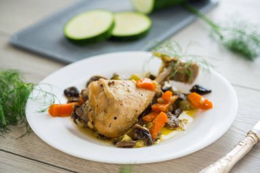 Mantarlı kızarmış tavuk ve ahşap bir masada bir tabakta sebze. .