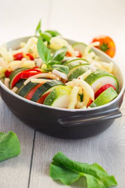 Çiğ kabak ve domates dilimlenmiş ve seramik bir tabakta pişirmek için hazırlanmış sebze aperatifi. .